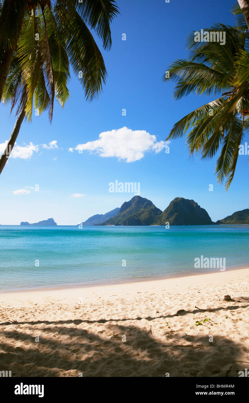 Blick durch Palmen, Strand, Meer und Inseln; Las Reetdächern; El Nido; Bacuit Archipels; Palawan; Philippinen. Stockfoto