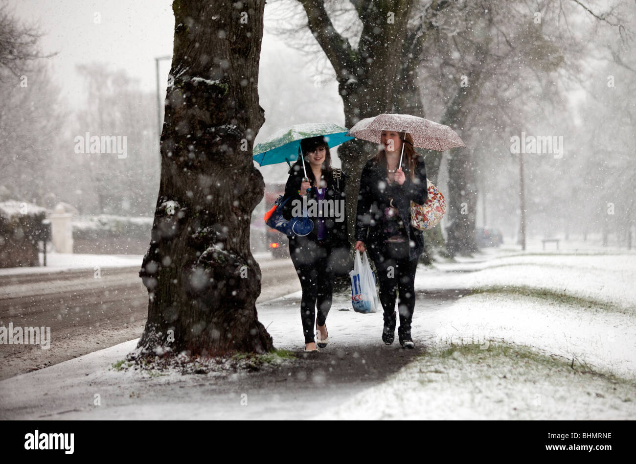 Zwei Mädchen, die zu Fuß durch einen Schneesturm in Malvern, Großbritannien Stockfoto