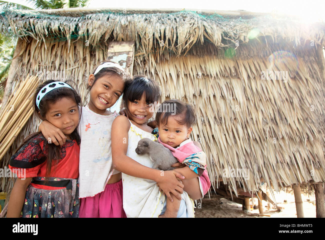 Heimatdorf Kinder halten einen Welpen; Darocotan Insel; Bacuit Archipels; Palawan; Philippinen Stockfoto