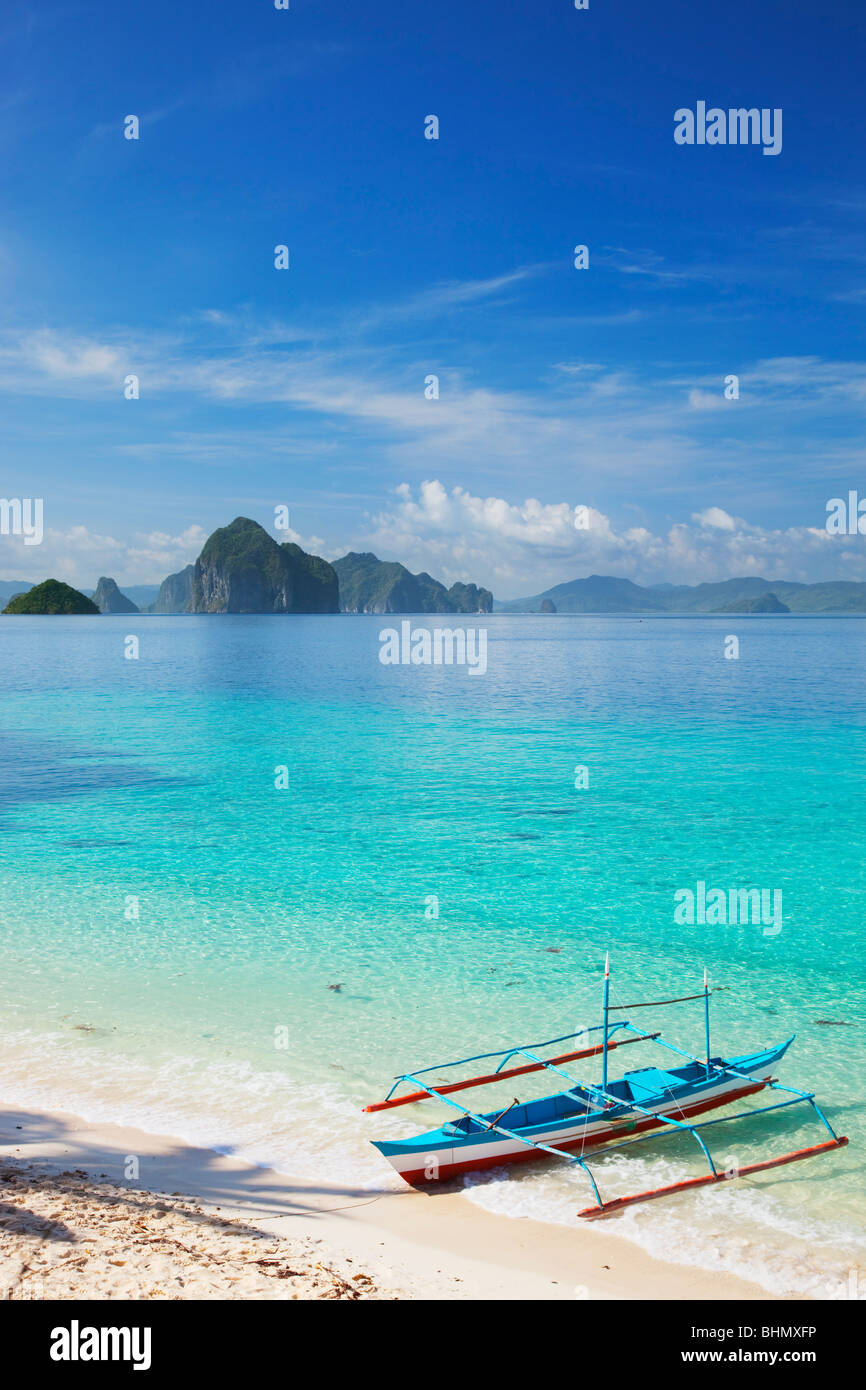 Banca Boot im seichten Wasser und Inseln; Sieben Commandos Strand; Bacuit Archipels; Palawan; Philippinen. Stockfoto