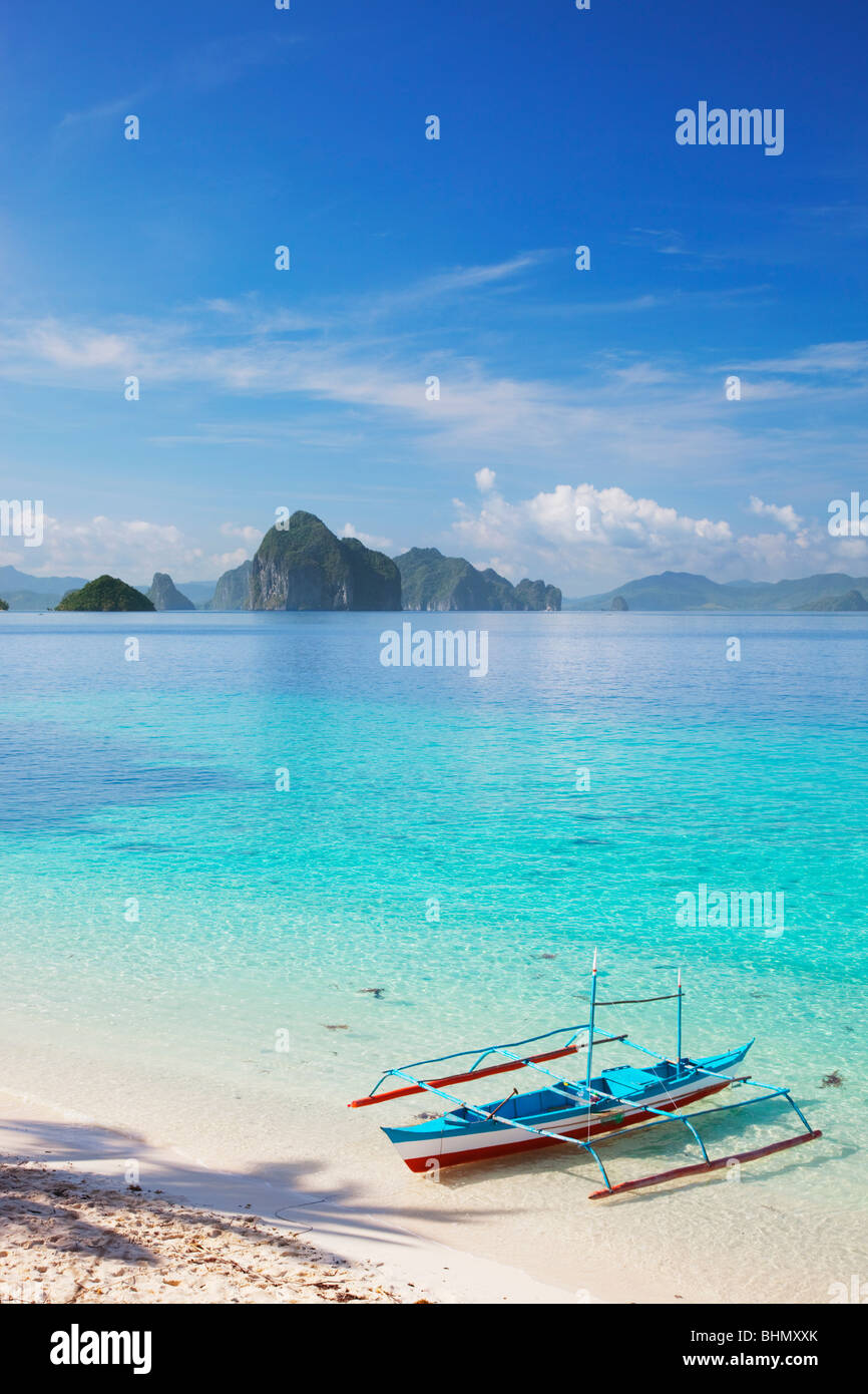 Banca Boot im seichten Wasser und Inseln; Sieben Commandos Strand; Bacuit Archipels; Palawan; Philippinen. Stockfoto