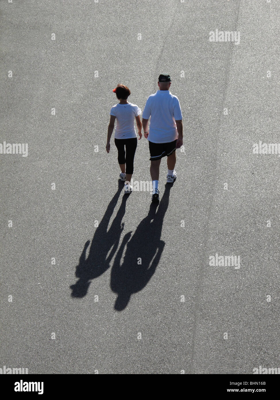 Paar mittleren Alters walking für Übung in der frühen Morgensonne Stockfoto