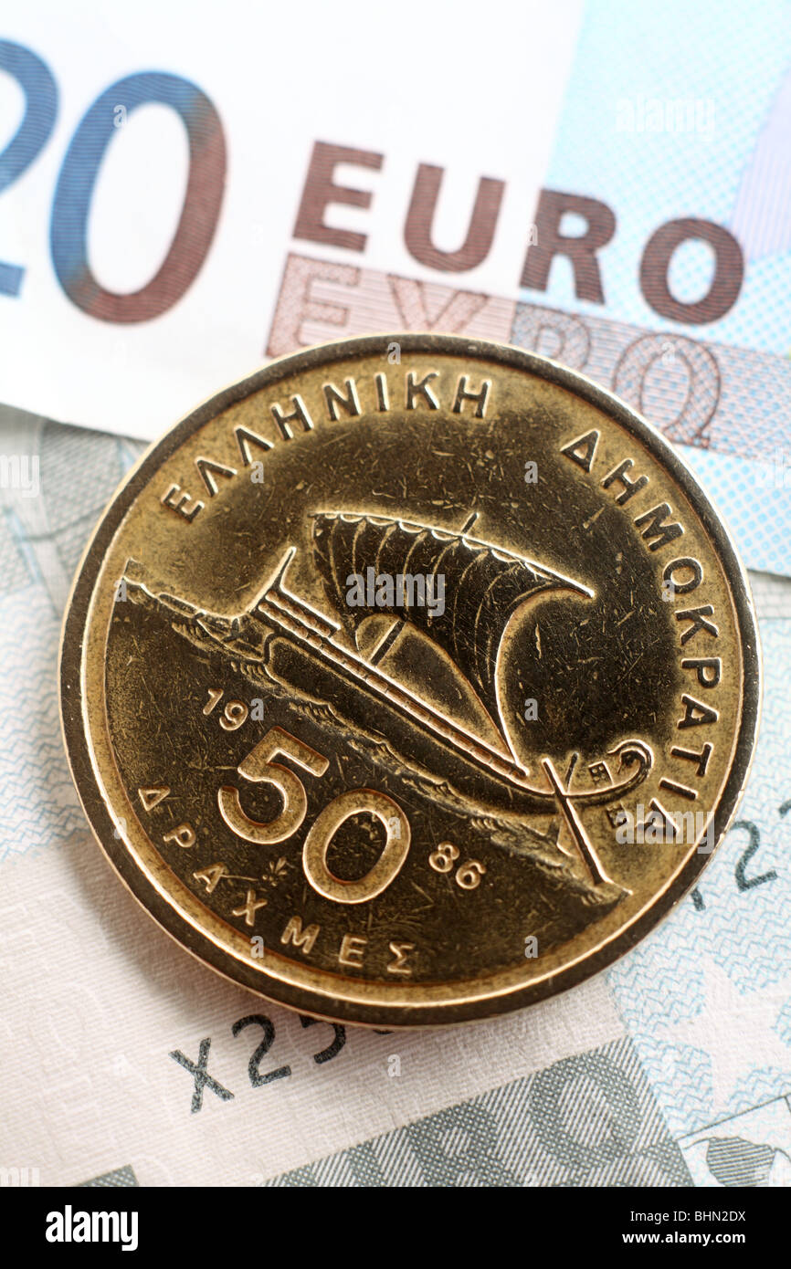 Eine 50 Drachmen-Münze, bis die Annahme der einheitlichen europäischen Währung auf einem Hintergrund von Euro-Banknoten in Umlauf. Stockfoto