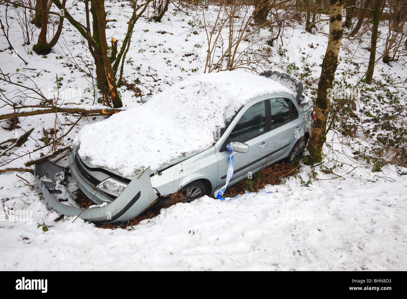 Abgestürztes Auto an der Seite einer vereisten Straße. Stockfoto