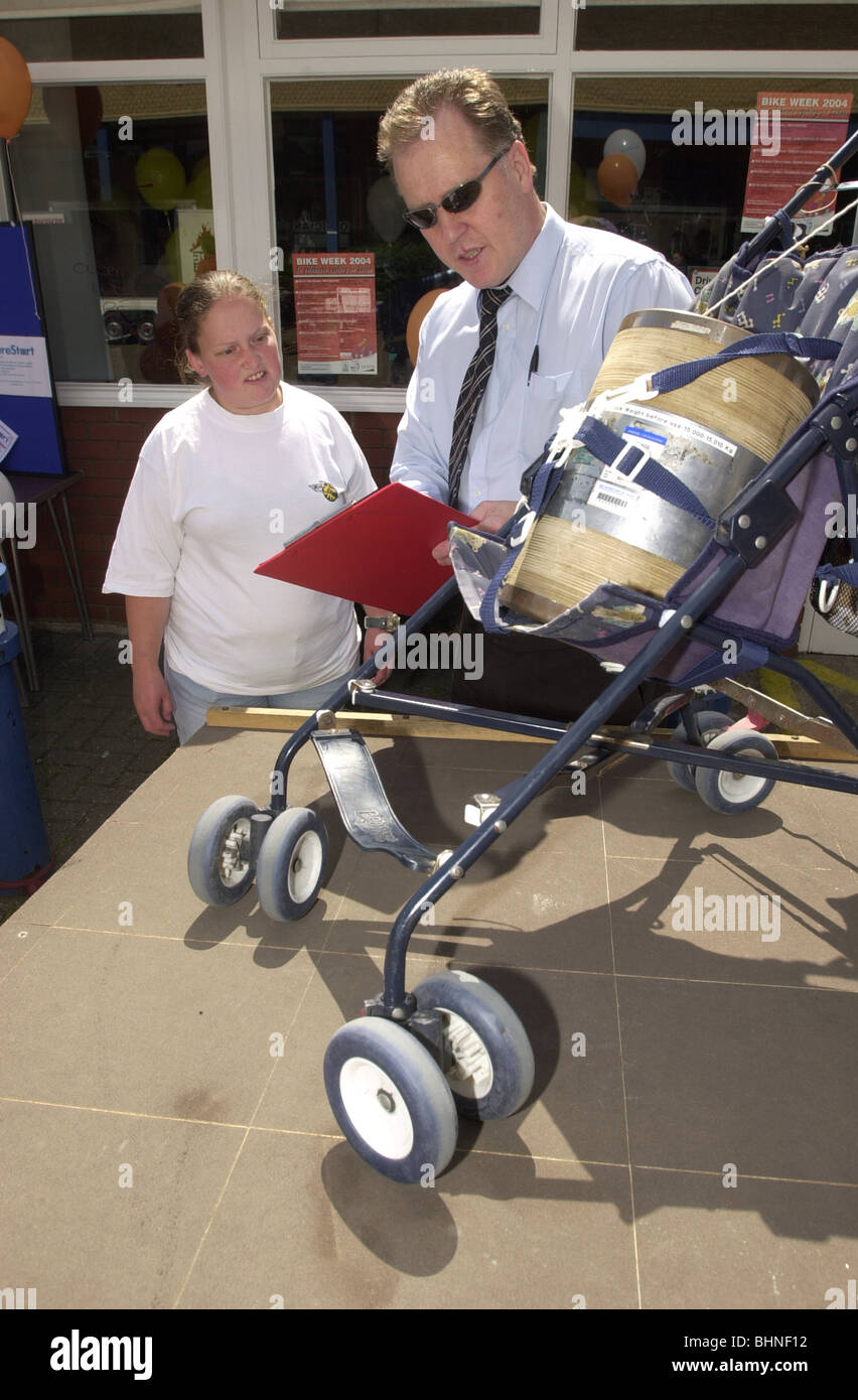 Trading Standards Offizier zeigt einer jungen Mutter, wie zu sehen, ob ihr Kinderwagen das Gesetz UK erfüllt Stockfoto