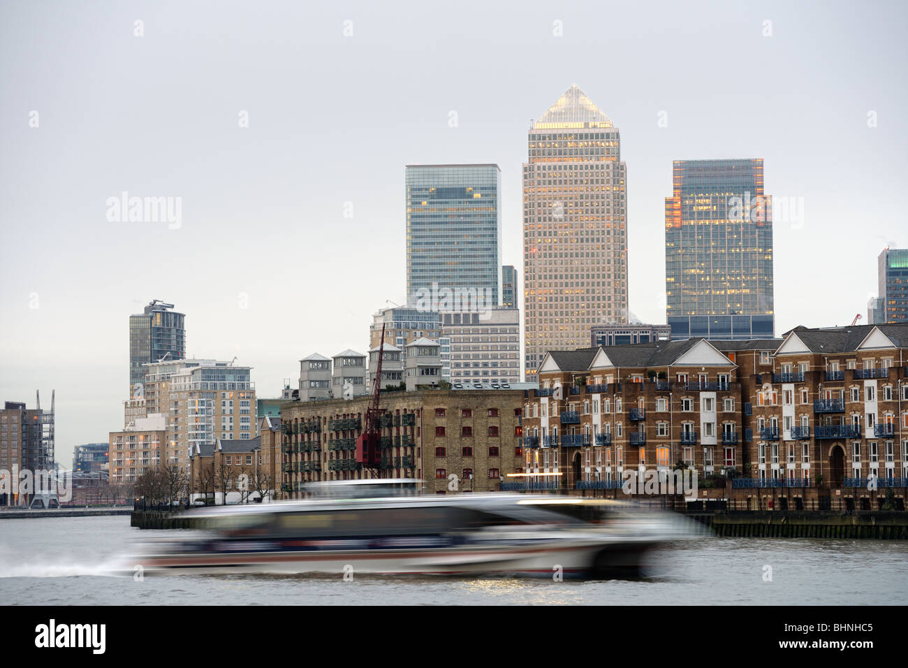 Schnelle Riverbus in der Abenddämmerung auf der Themse, London, England, Vereinigtes Königreich, mit Canary Wharf im Hintergrund, Reisen Stockfoto