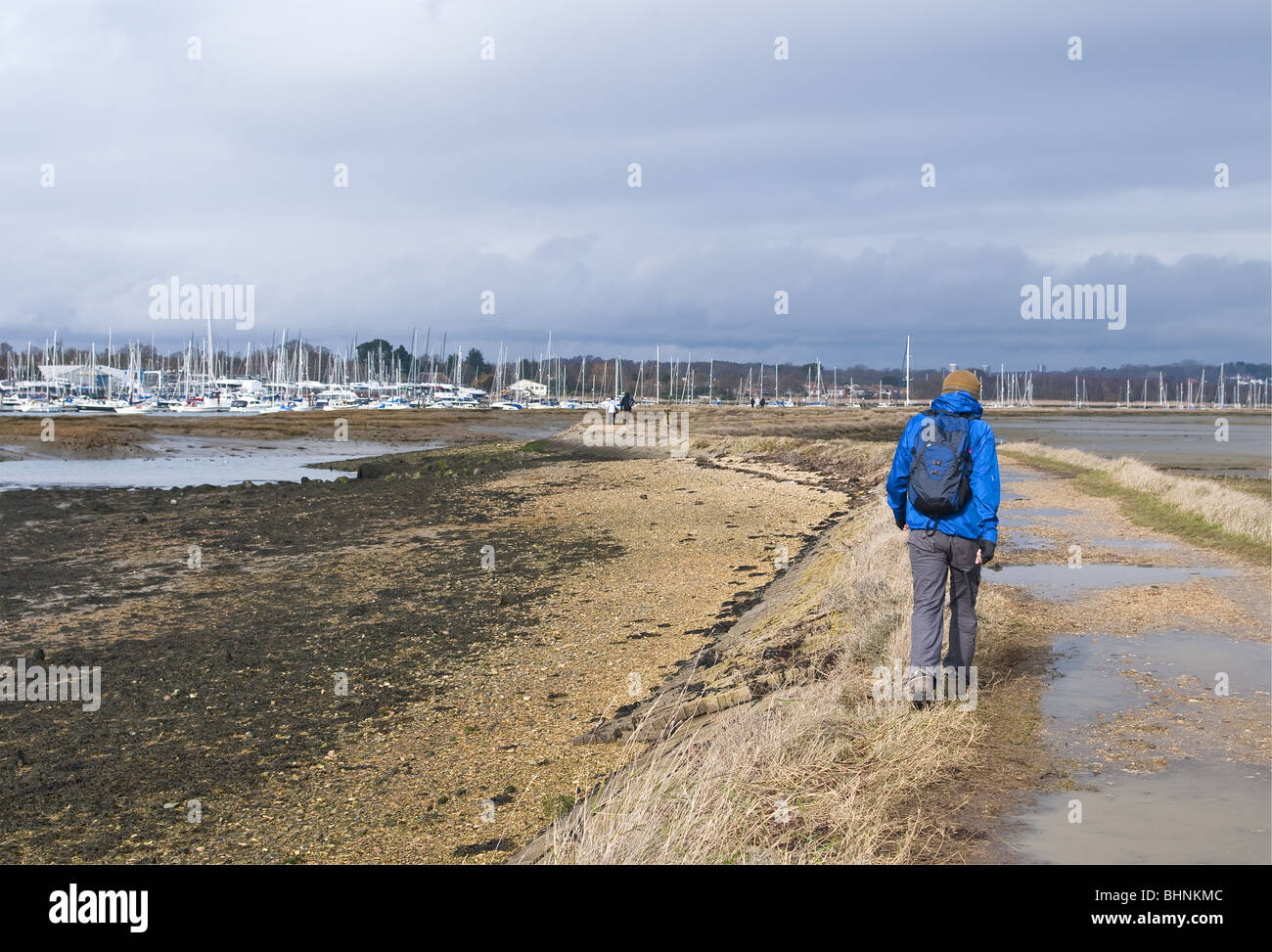 Walker auf den erhöhten Kiesweg neben dem Fluss Hamble Mündung und Wattenmeer, Hamble-Le-Reis, Southampton, Hampshire, UK Stockfoto