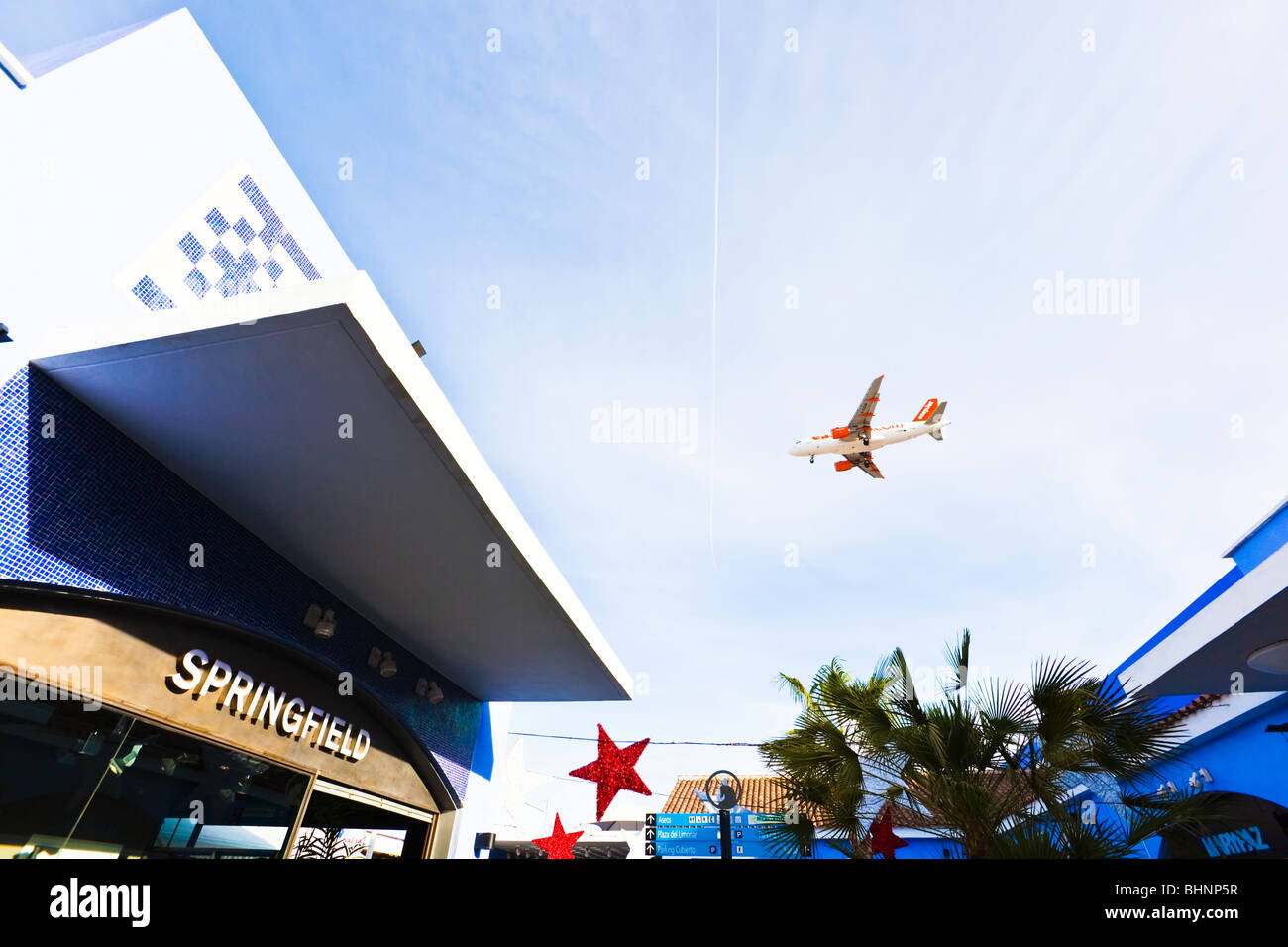 EasyJet Flugzeug fliegt über Plaza Mayor Einkaufszentrum, Malaga, Costa Del Sol, Spanien. Springfield-Shop im Vordergrund. Stockfoto