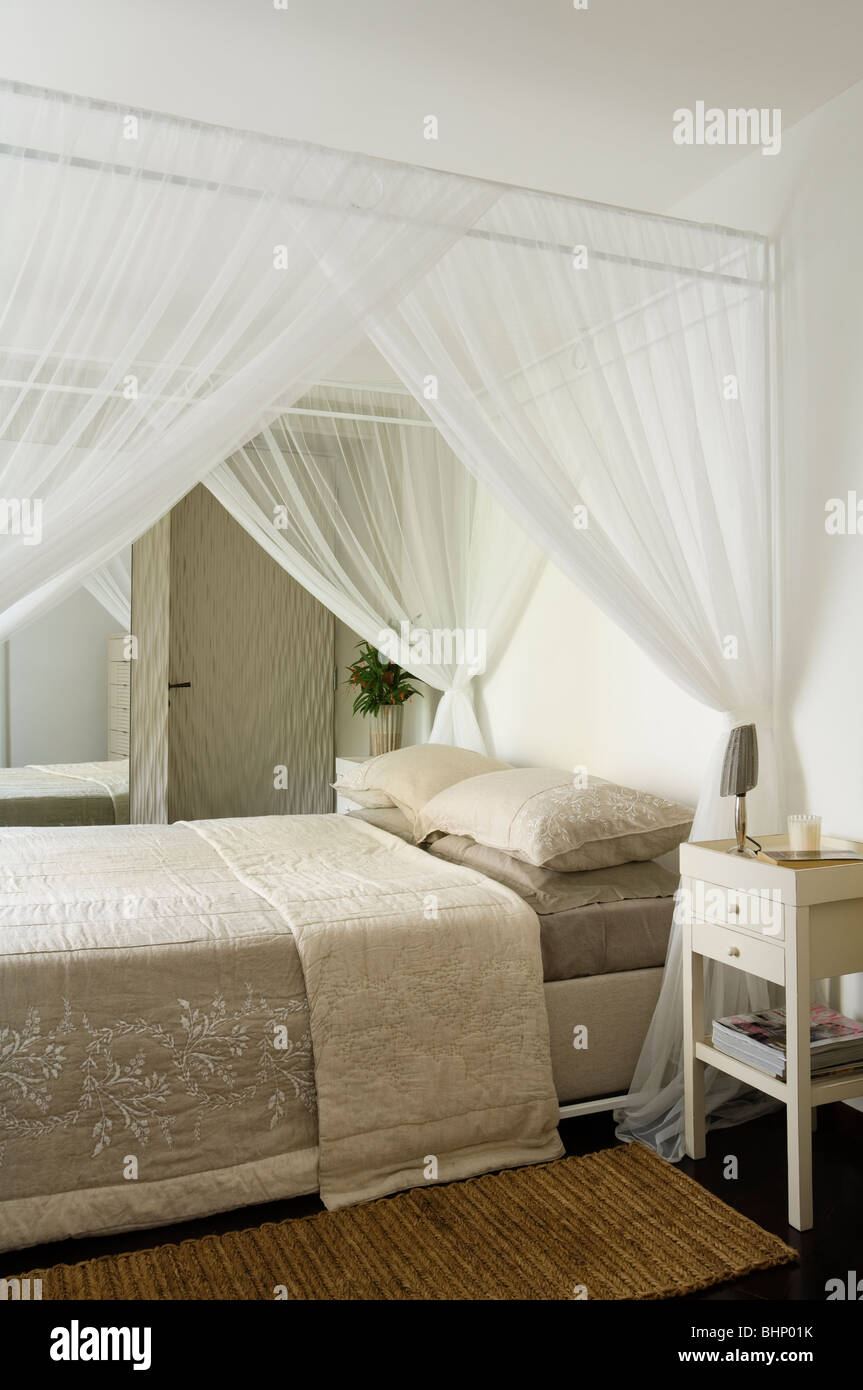 Schlafzimmereinrichtungen Bett mit Vorhängen Musselin und Beige quilt Stockfoto