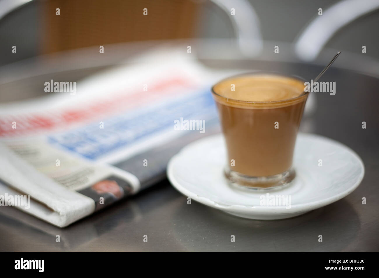 Kleiner Espresso mit Milch, Cortado und eine Zeitung auf einen Balken Stockfoto