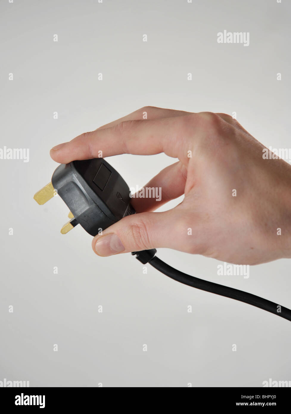 UK-Stil 3-Pin-Stecker in eine Hand gehalten, als ob Sie in ein 240V Steckdose Strom-Steckdose stecken Stockfoto