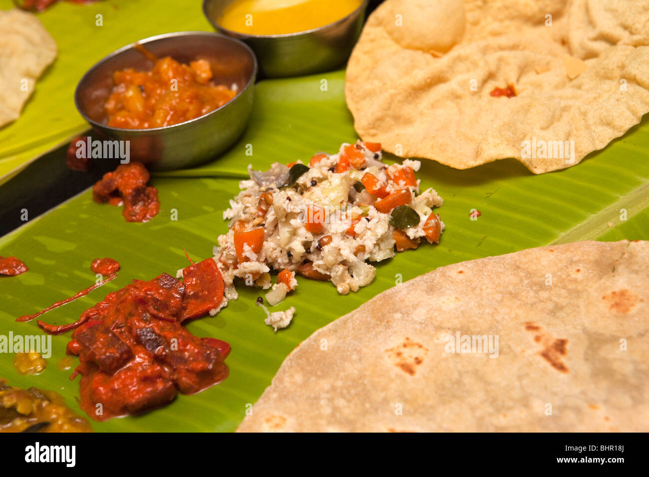 Indien, Kerala, Munnar, Nahrung, Cocounut-Chutney, Lime Pickle, Papad, Chapati auf Banane Blatt Thali Essen Stockfoto
