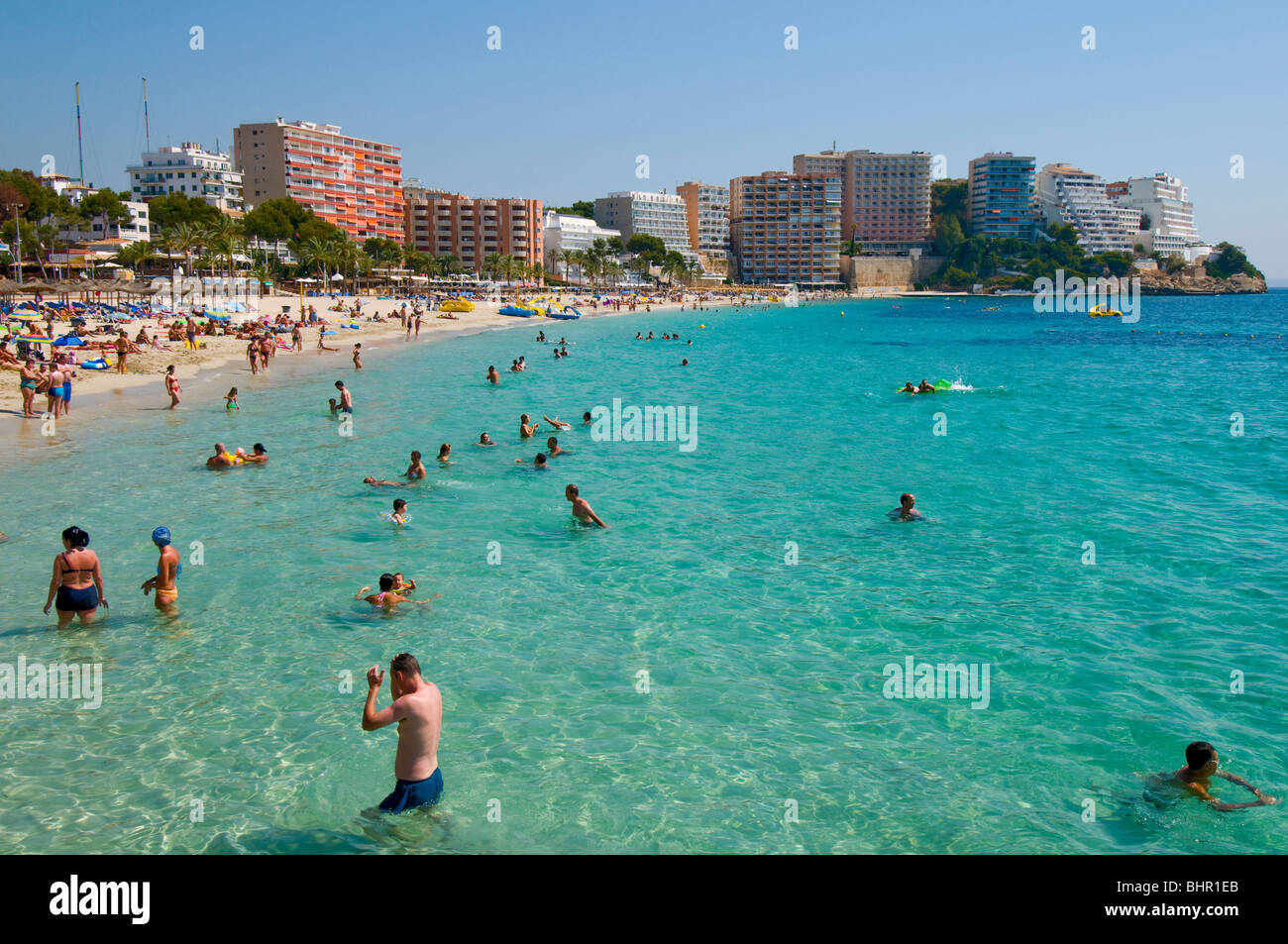 Überfüllten Strand mit eine Menge Leute in das Blau des Meeres genießen und entspannen dort Urlaub mit in den Hintergrund-hotels Stockfoto