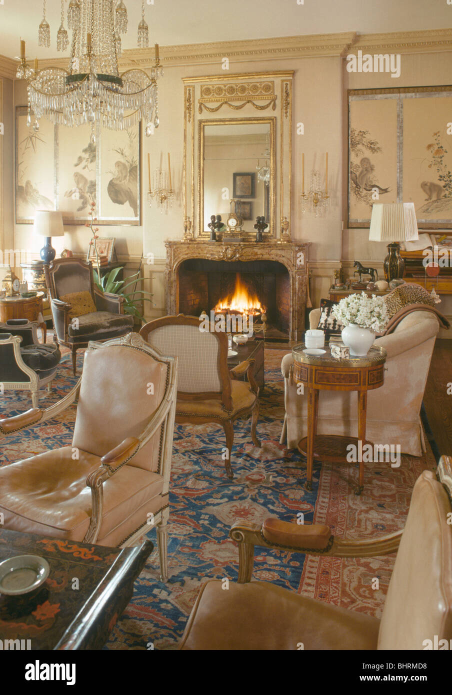 Antike Möbel und gemusterten Teppich im Stadthaus Salon mit brennenden Feuer im Kamin Stockfoto