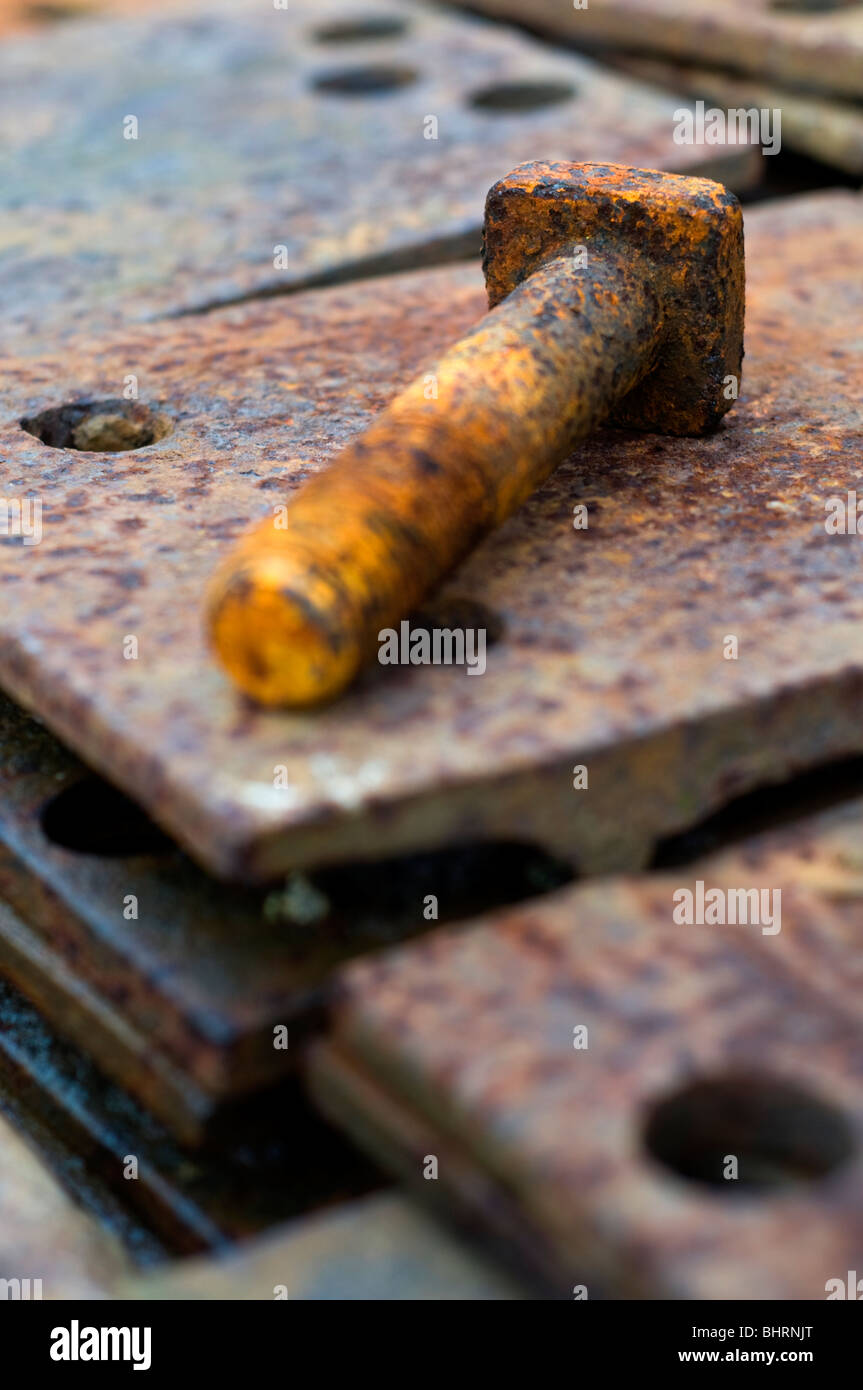 Eine rostige Schraube auf einem Haufen Rost Metallplatten Stockfoto