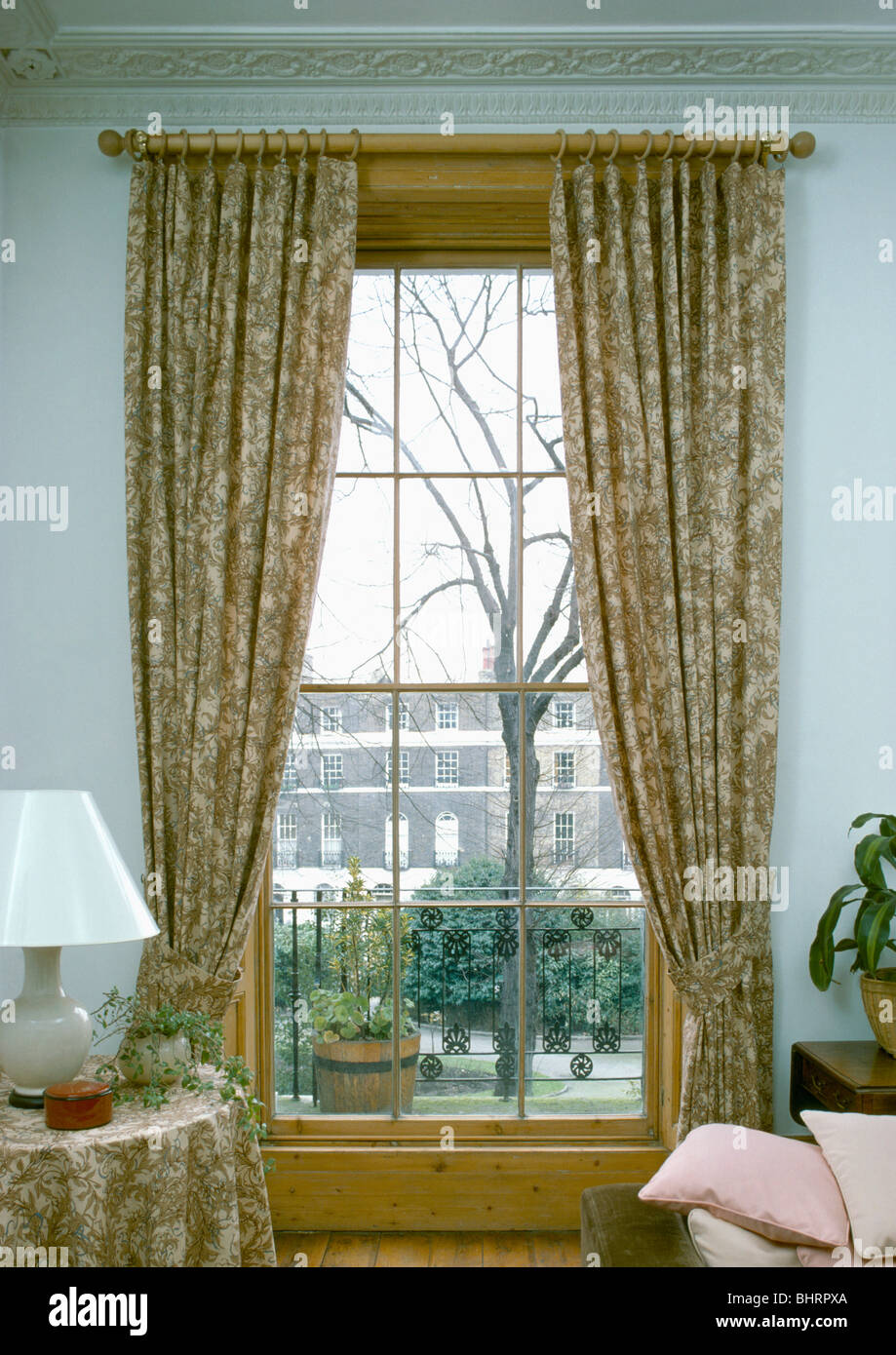 Gemusterte Gardinen an Schiebefenster mit Blick auf die Straße im  Stadthaus-Wohnzimmer Stockfotografie - Alamy