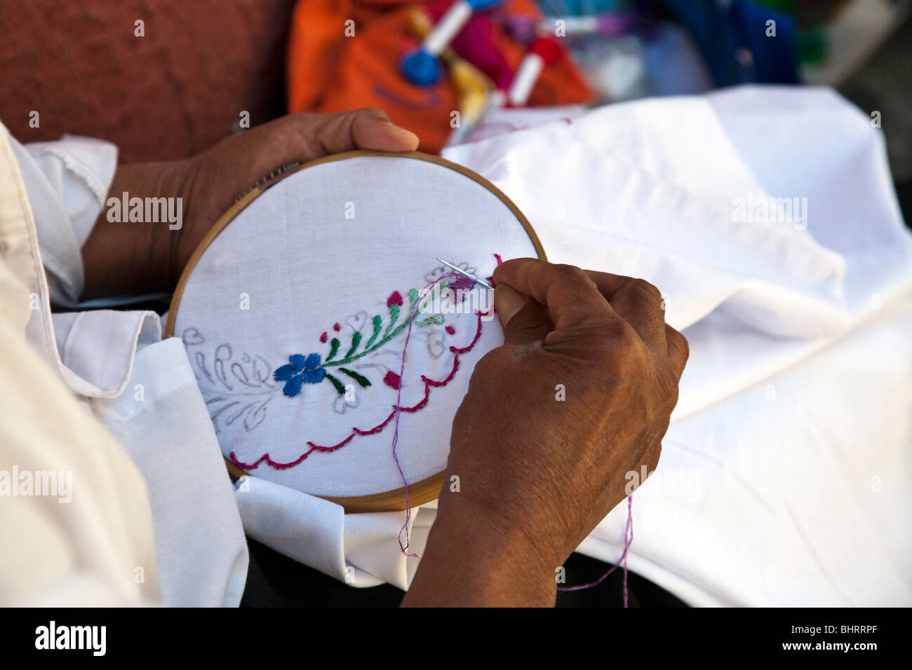 Hand sticken Stickerei eines traditionellen bestickte Bluse mit Stickerei Hoop auf der Calle Macedonio Alcala Bereich geschlossen nach Oaxaca Stockfoto