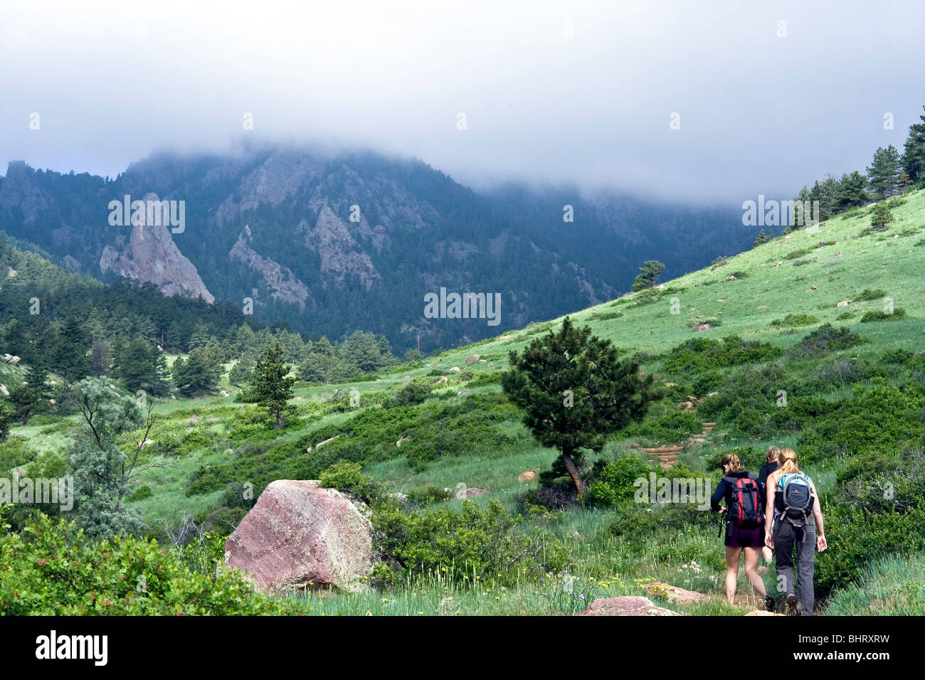 Drei Menschen wandern vom Eldorado Springs Canyon South Boulder Peak im Frühsommer. Stockfoto