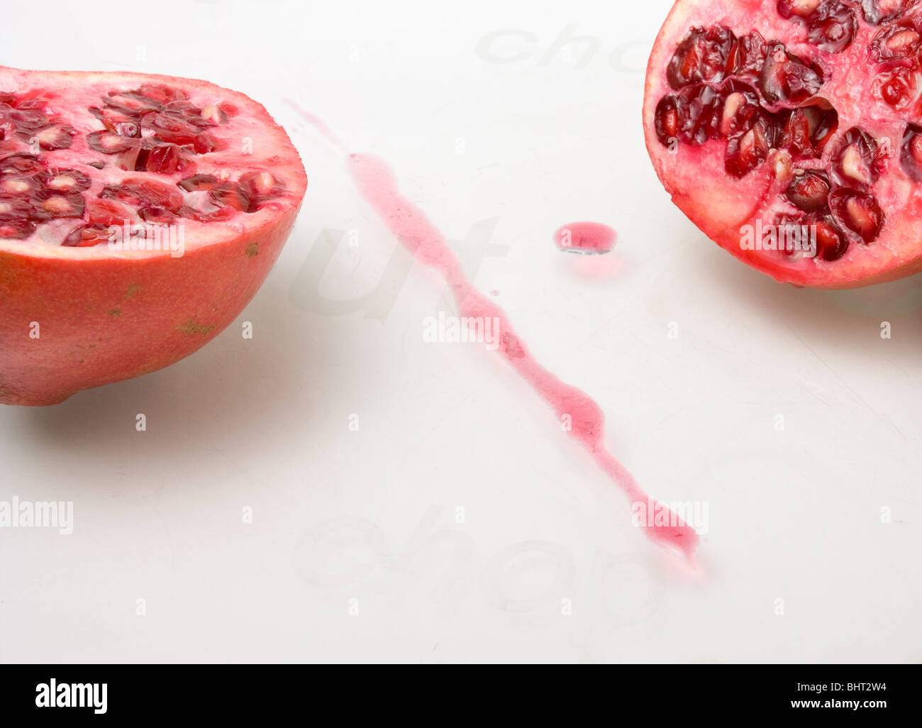 Lebhafte rote geschnittenen Granatapfel-Frucht gegen Glas geätzt Schneidebrett. Stockfoto