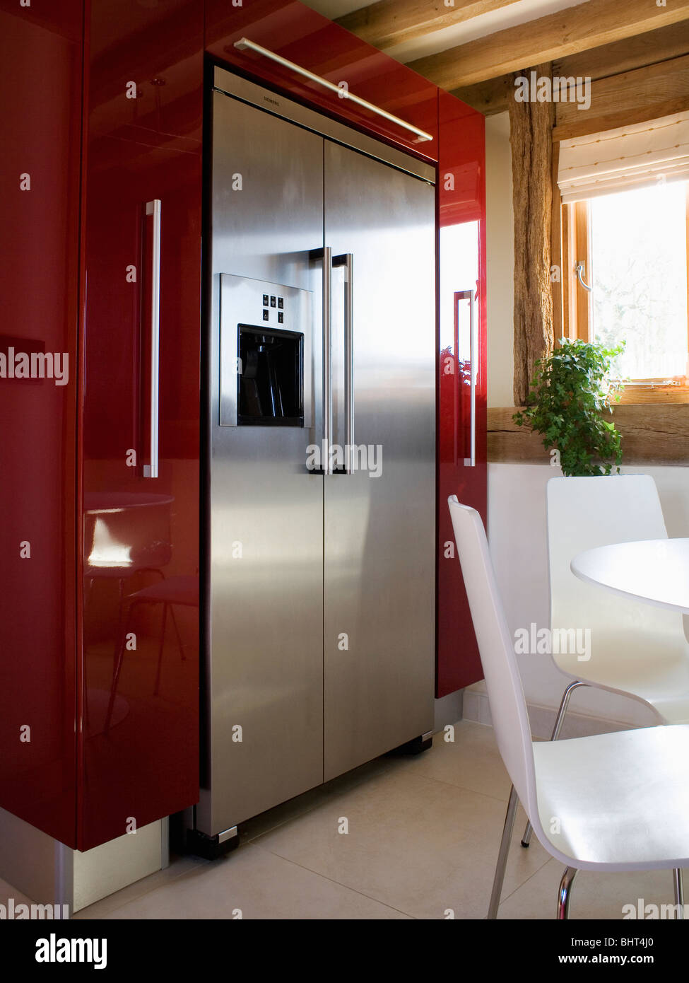 Große Edelstahl-amerikanische Kühl-Gefrierkombination in moderne Küche  Esszimmer mit weißen Tisch und Stühlen Stockfotografie - Alamy