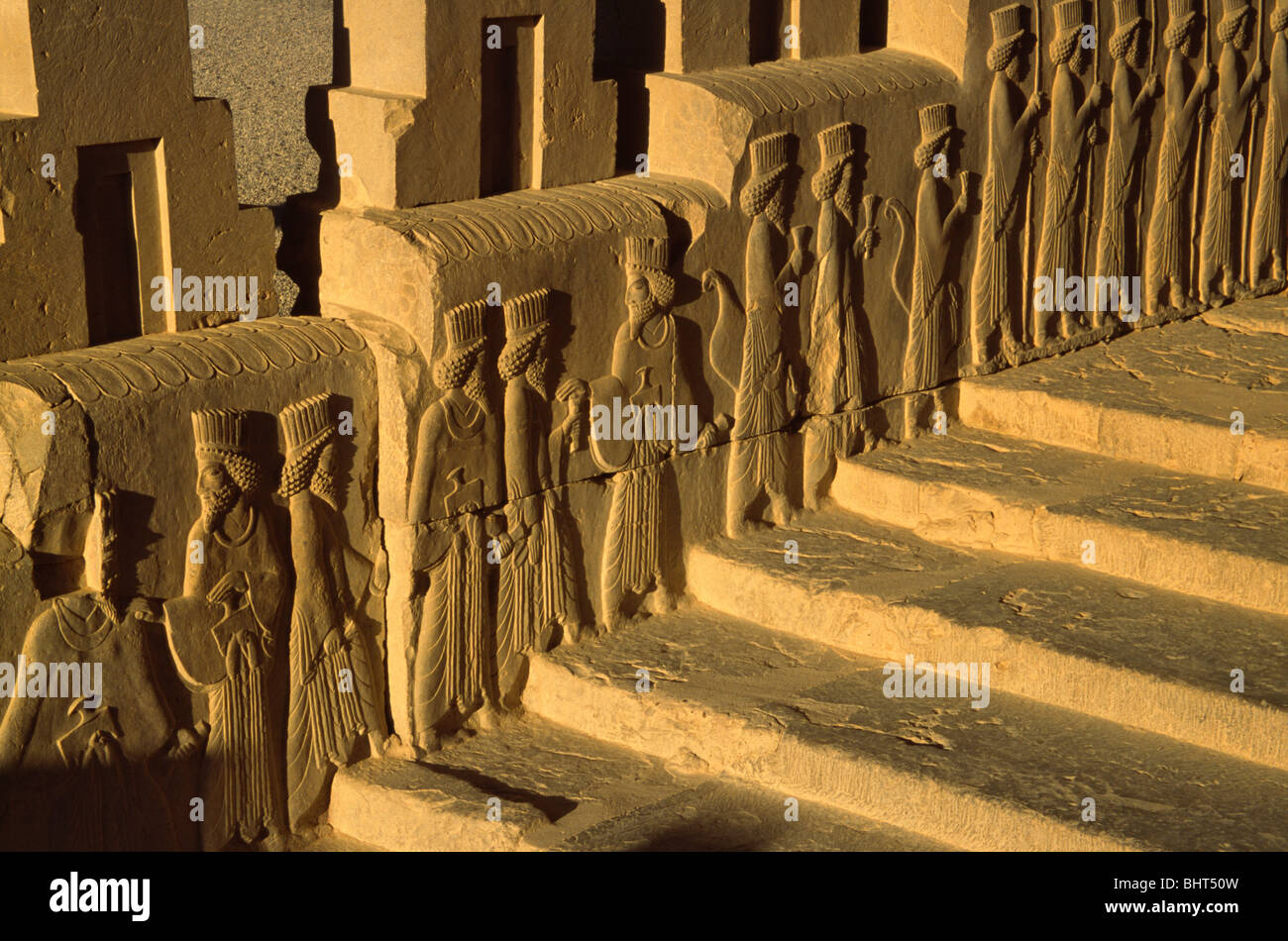 Blick auf den Sonnenuntergang der Reliefskulptur Thema Völker des achämenidischen Reiches steigen die Treppe, Persepolis, Iran Stockfoto