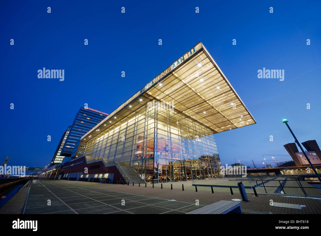 Amsterdamer Muziekgebouw Aan ' t IJ, Musik-Gebäude an der IJ; Star Ferry-Restaurant in der Abenddämmerung. Mövenpick Hotel; Kreuzfahrt-Terminal. Stockfoto