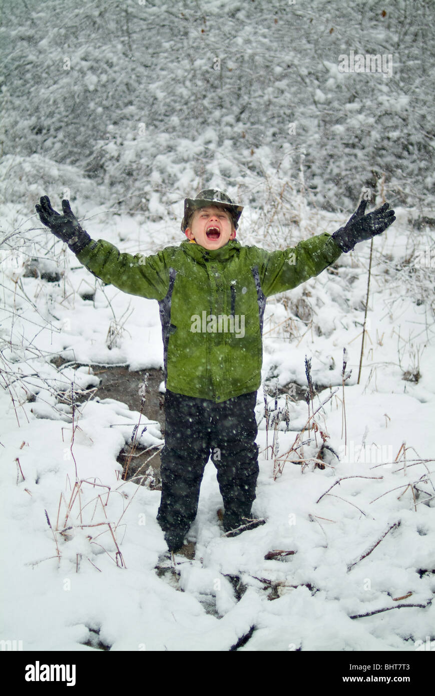 Kind spielt in schneebedecktes Feld Stockfoto