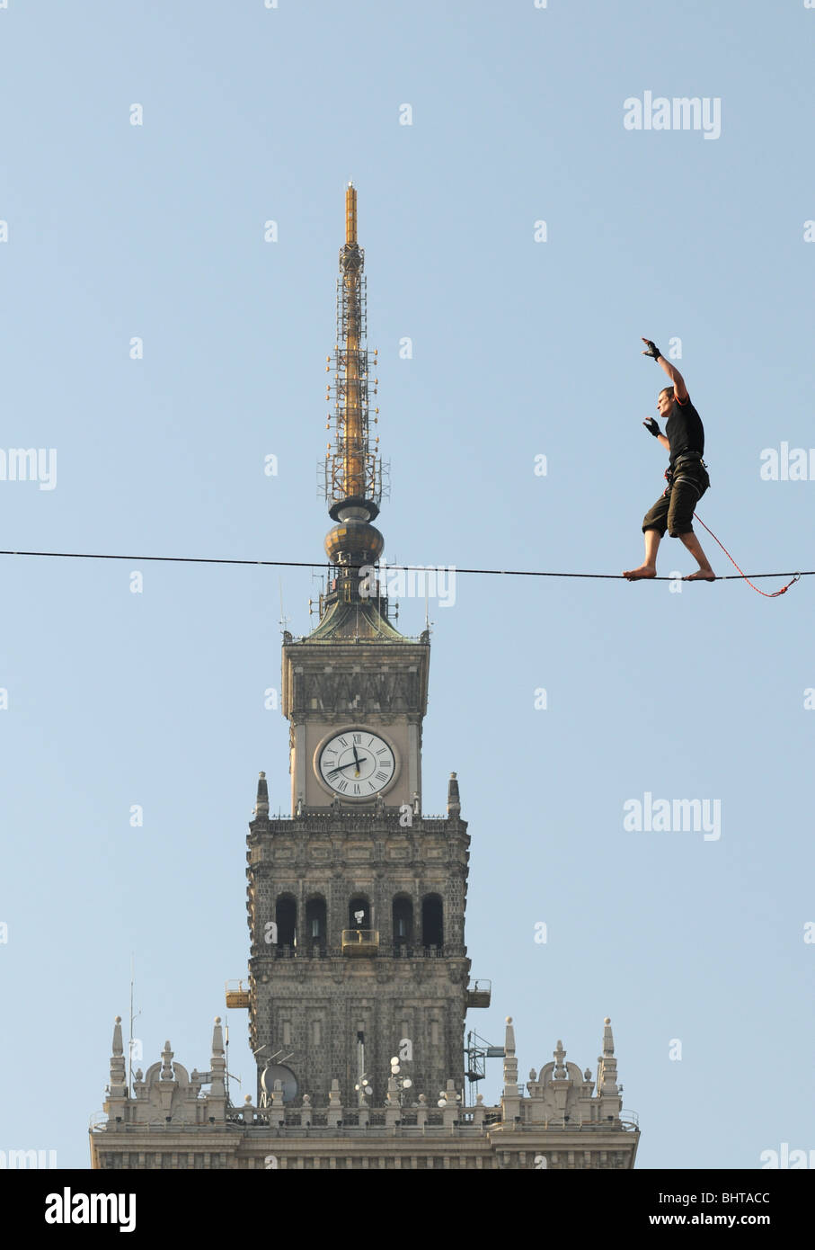 Polnische Slackliner Damian Czermak während Show in Warschau, Polen. Palast der Kultur und Wissenschaft Gebäude im Hintergrund. Stockfoto
