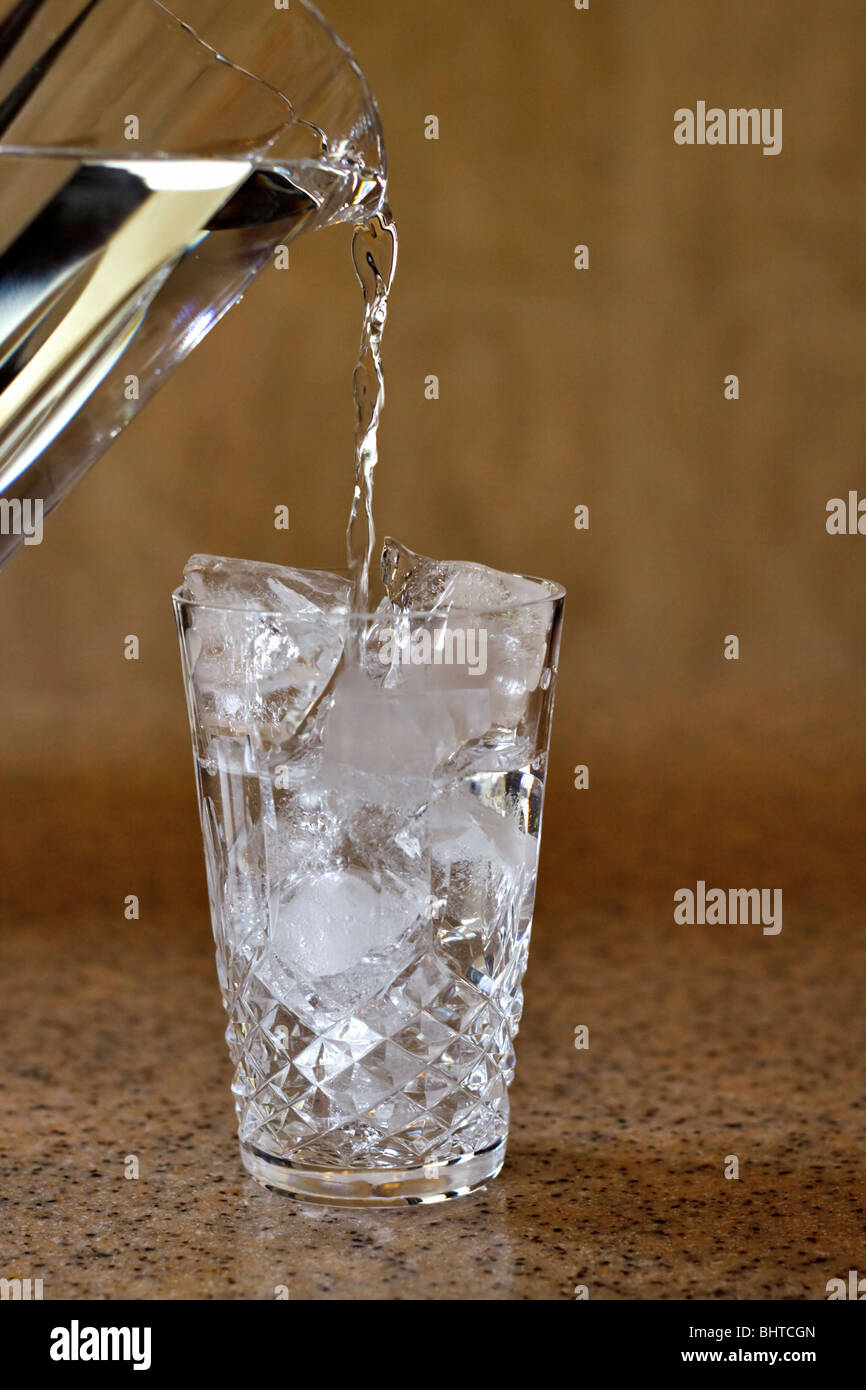 Gießen ein Glas Eiswasser Stockfoto