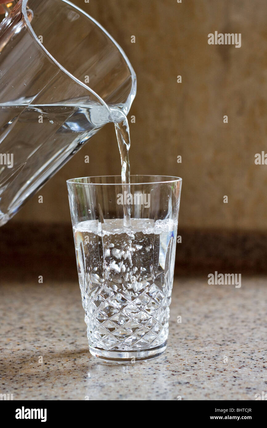 Gießen ein Glas Wasser Stockfoto