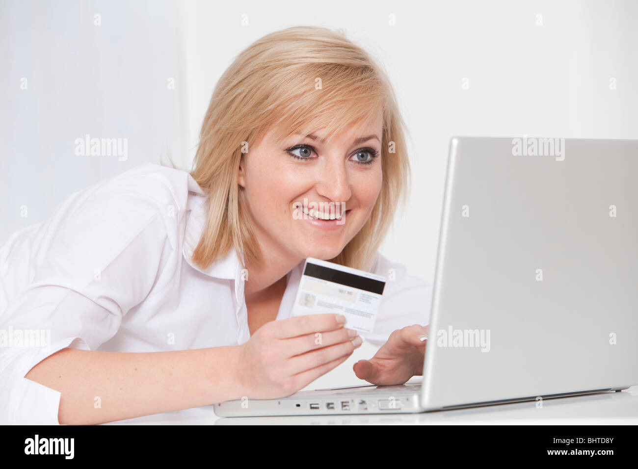 junge Frau mit Laptop und Kreditkarten-online-shopping Stockfoto