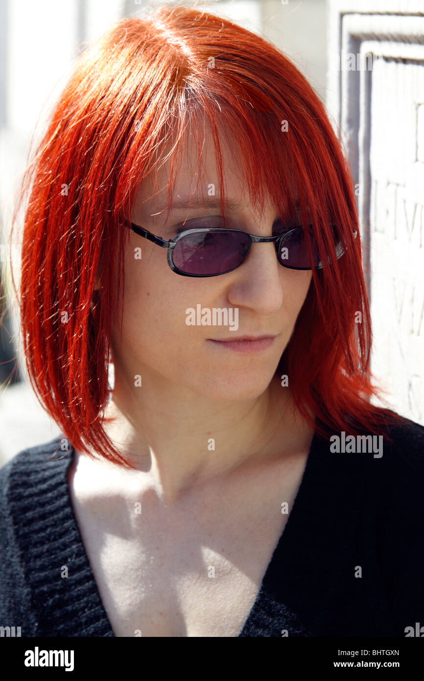 Rothaarige Frau mit Sonnenbrille Stockfoto