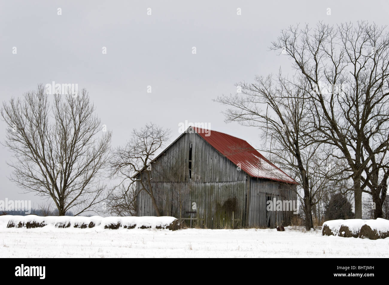 Alte Scheune und Heuballen im Schnee im Harrison County, Indiana Stockfoto