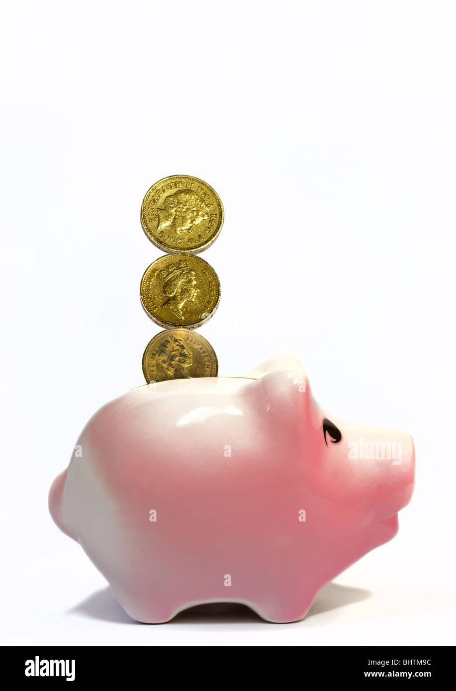 Pfund-Münzen und rosa Sparschwein Stockfoto