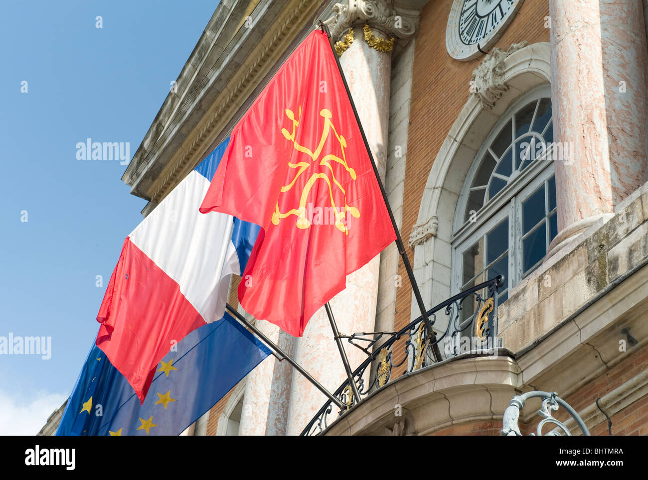Europäische, Französische Tricolore und Occitane flags außerhalb der Place du Capitole in Toulouse, die Hauptstadt der Region von Occitanie, Frankreich Stockfoto