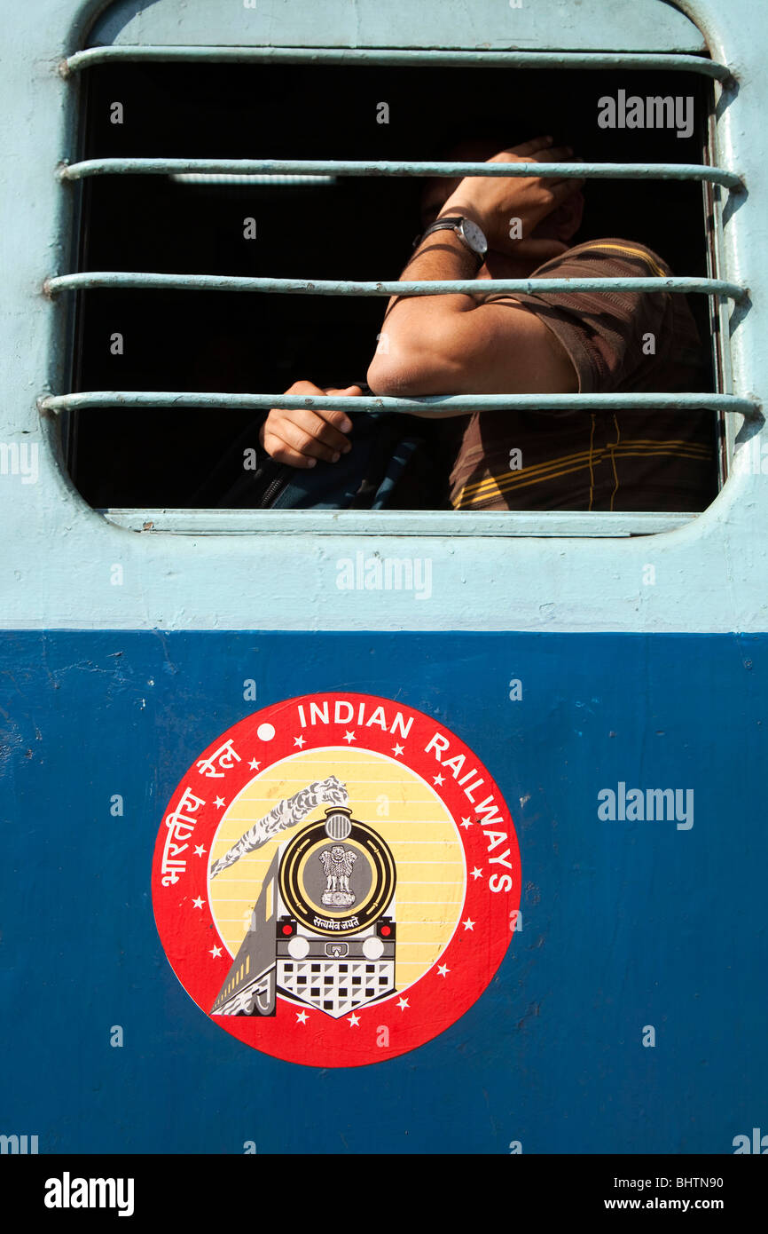 Indien, Kerala, Kollam, Bahnhof, Indian Railways Abzeichen auf Panel unter vergitterten Wagen zweiter Klasse-Fenster Stockfoto