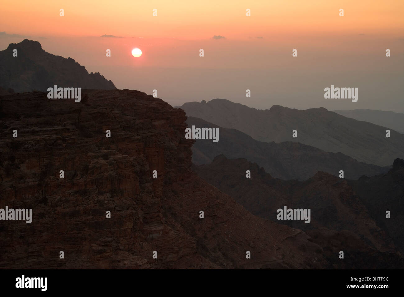 Sonnenuntergang über den Bergen von Petra betrachtet aus dem Kloster oder El Deir in Petra, Wadi Musa, Jordanien. Stockfoto