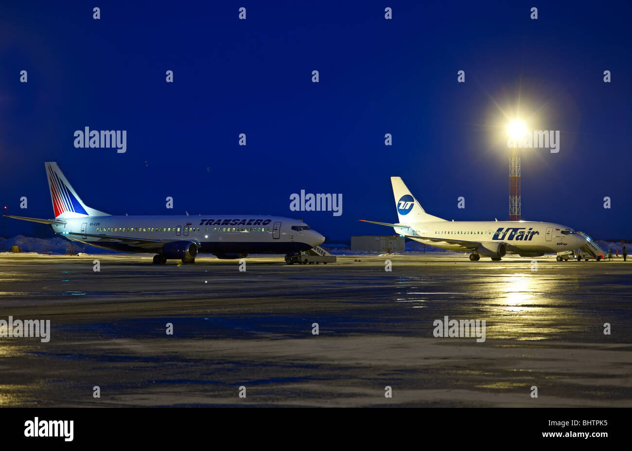 Nacht-Flughafen. "Transaero" Boeing 737-4Y0 (EI-CZK) und UT-Air Boeing 737-524 (VP-BYM). «Tolmachevo», Novosibirsk, Russland. Stockfoto