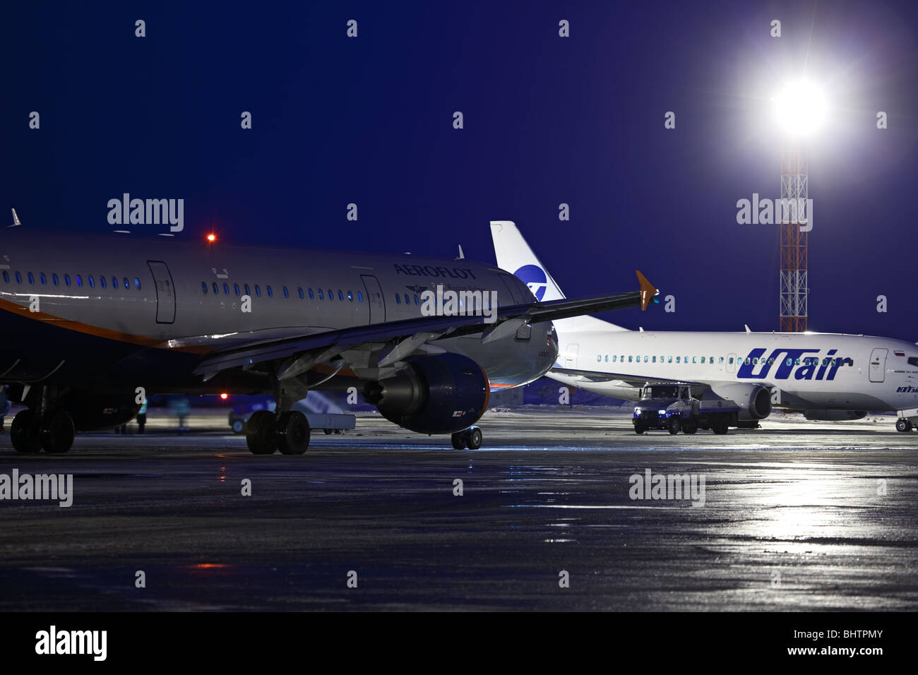 Nacht-Flughafen. Aeroflot A321-211 (VP-BUM) und UT-Air Boeing 737-524 (VP-BYM) auf dem Flugplatz. «Tolmachevo», Novosibirsk, Russland. Stockfoto