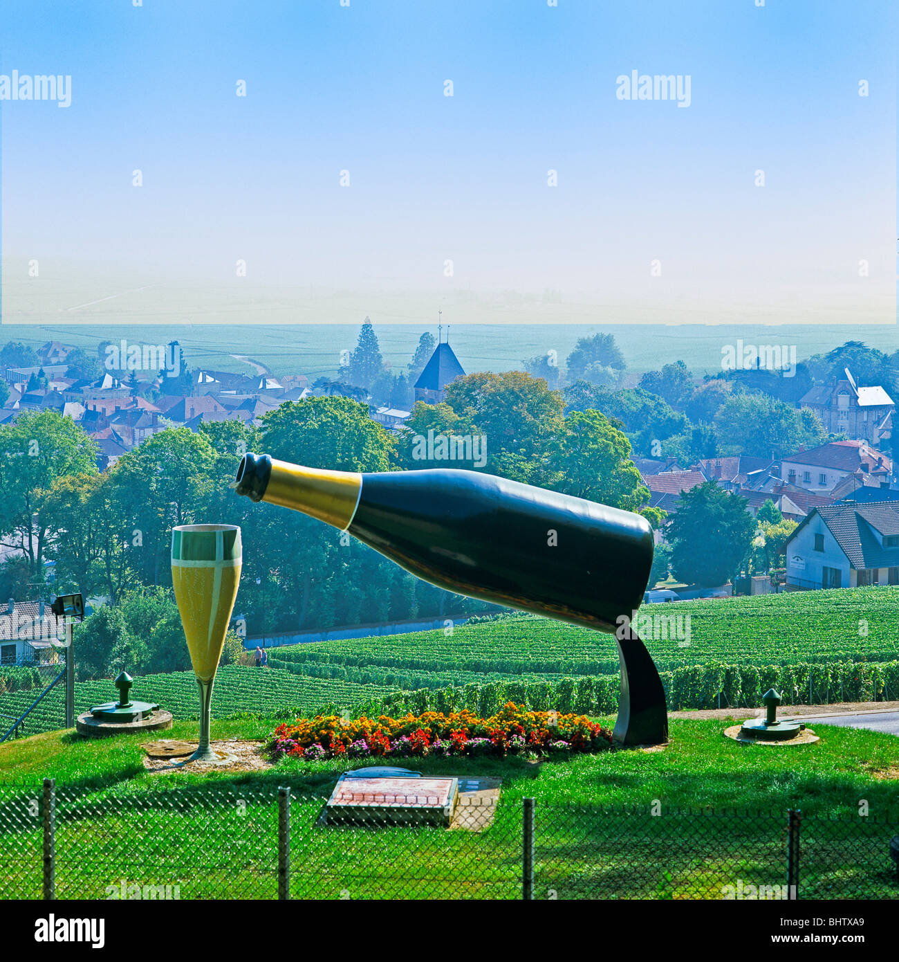 Hilltop riesige Flasche Champagner in die riesigen Glas, Weinberge gießen, Avize Dorf in der Ferne, Marne, Champagner, Grand Est, Frankreich, Europa, Stockfoto