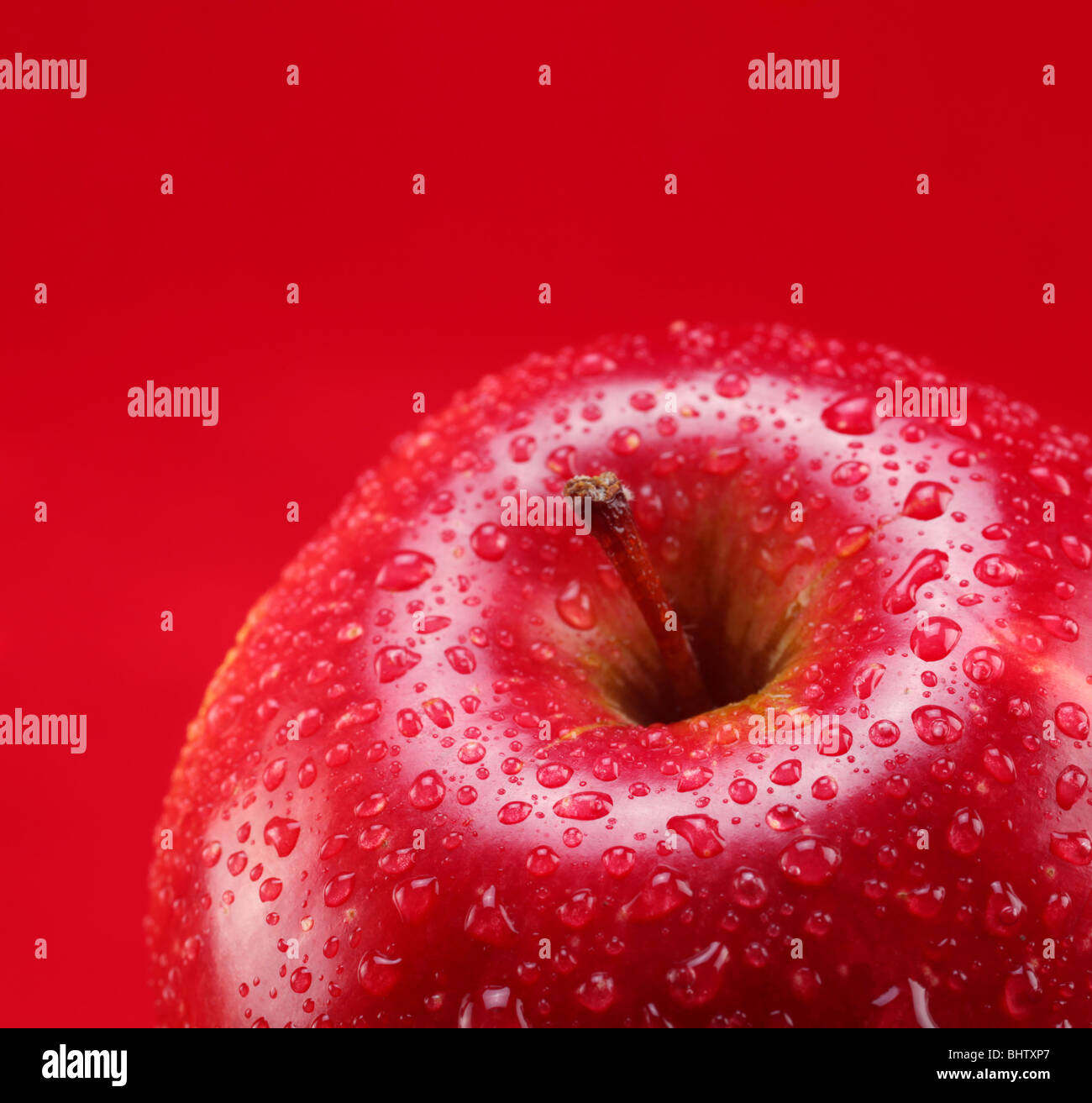 Roter Apfel mit Blatt auf rotem Grund Stockfoto
