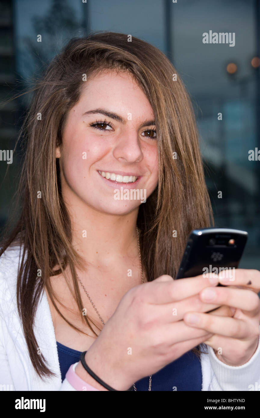 Porträt eines Mädchens mit braunen Haaren und braunen Augen halten ein i-Phone oder blackberry Stockfoto