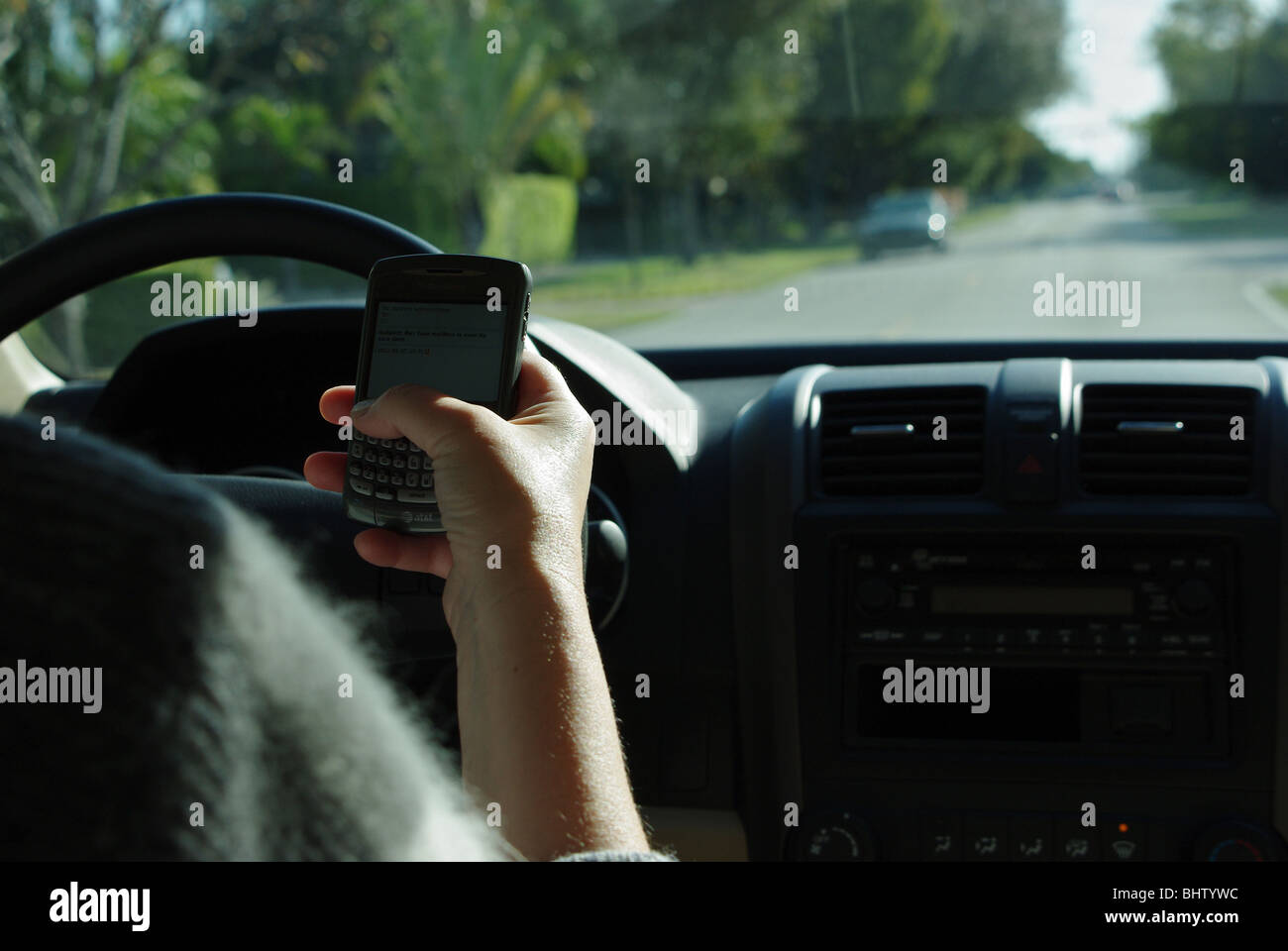 Frau nutzt PDA zu überprüfen und geben Sie SMS-Nachrichten während der Fahrt ihr Auto Stockfoto