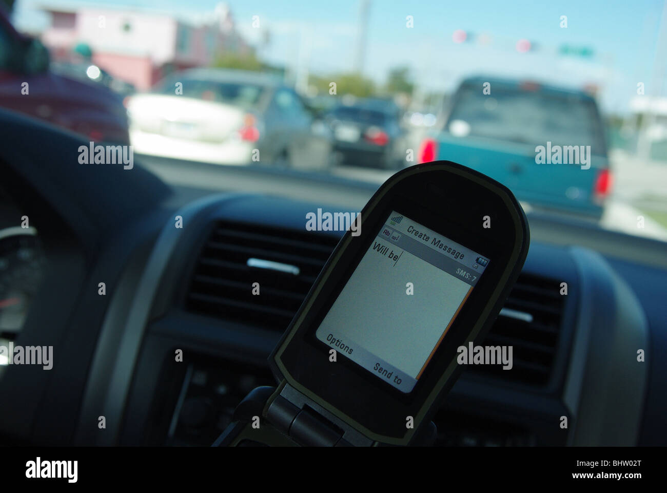 Frau nutzt PDA zu überprüfen und geben Sie SMS-Nachrichten während der Fahrt ihr Auto Stockfoto