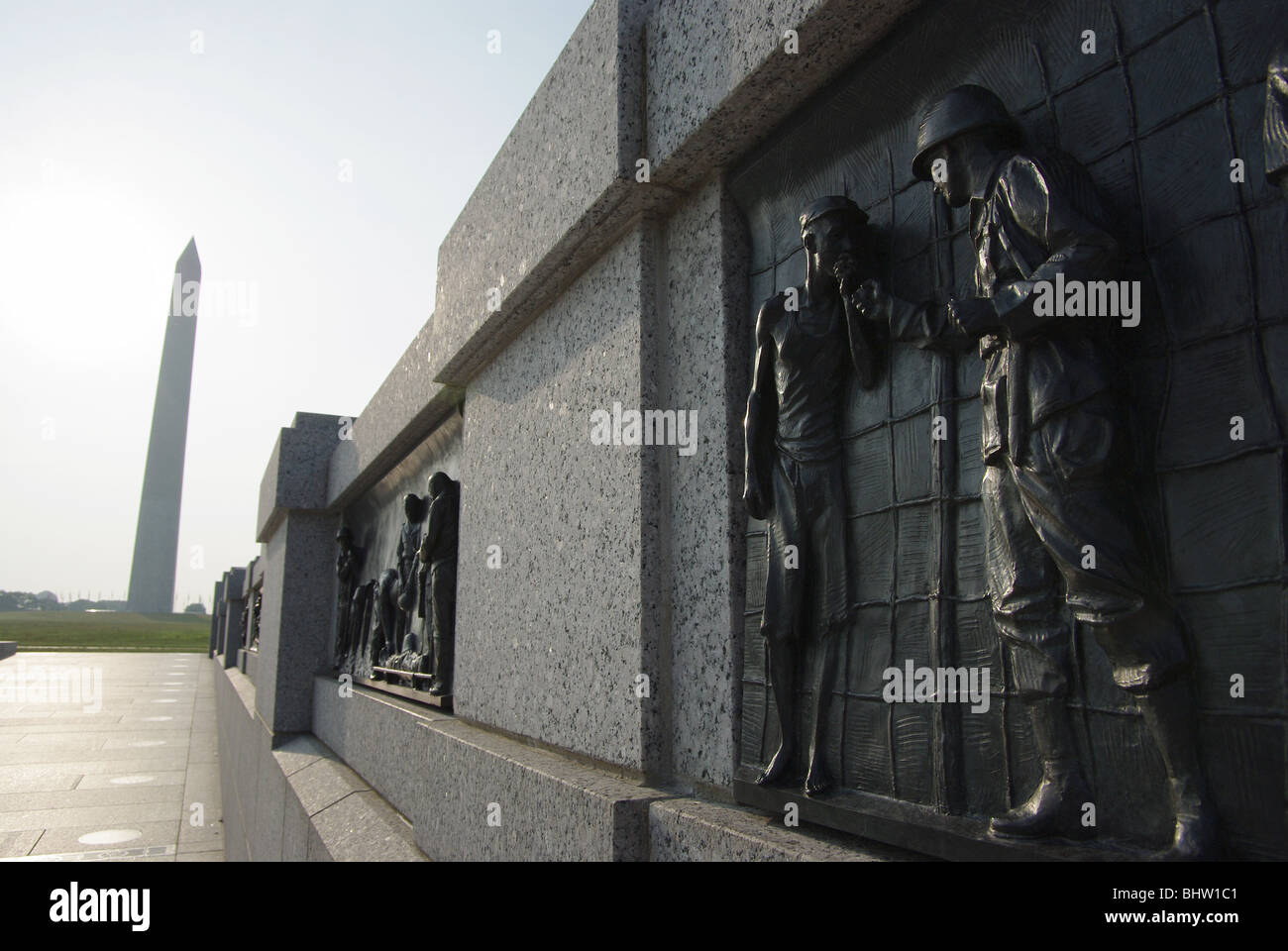 National Mall mit Bronze Bas Relief Panels auf dem Zweiten Weltkrieg Gedenkstätte mit Washington Monument im Hintergrund, Washington DC, USA Stockfoto
