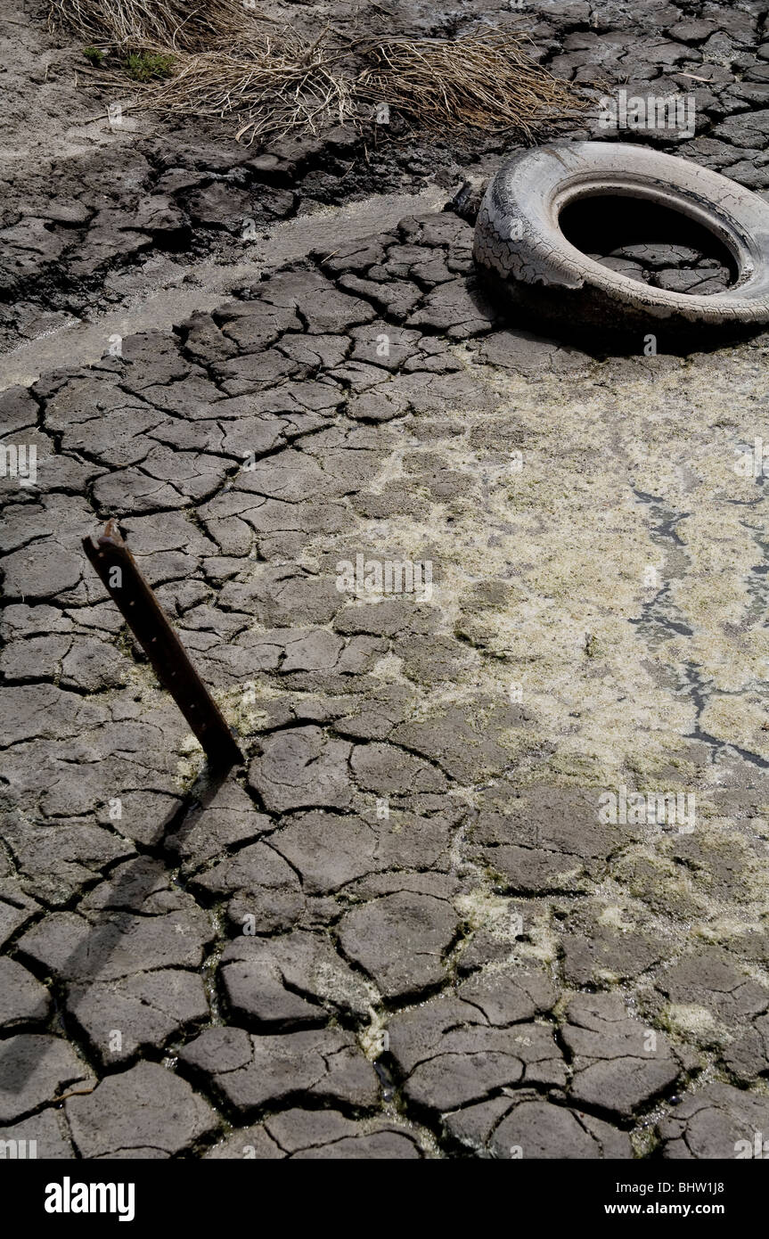 Autoreifen geworfen in einen Fluss, der endete im Schlamm des Flusses stecken. Stockfoto