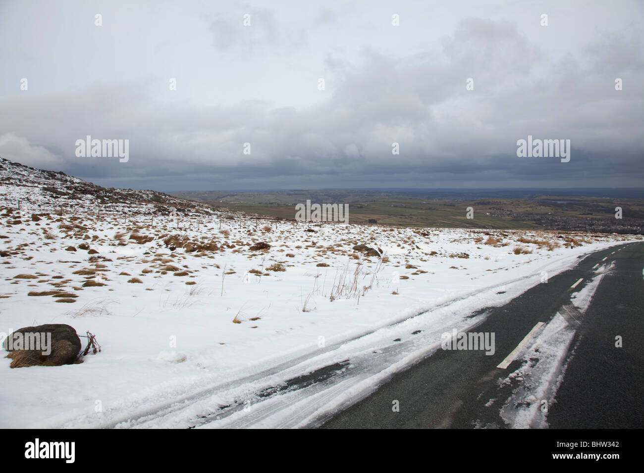 Blick Richtung Huddersfield in das Tal von oberhalb der Schneegrenze auf Yorkshire Moors, England im winter Stockfoto