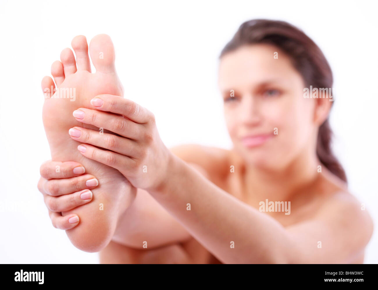 Junge Frau massiert ihren Fuß. Stockfoto