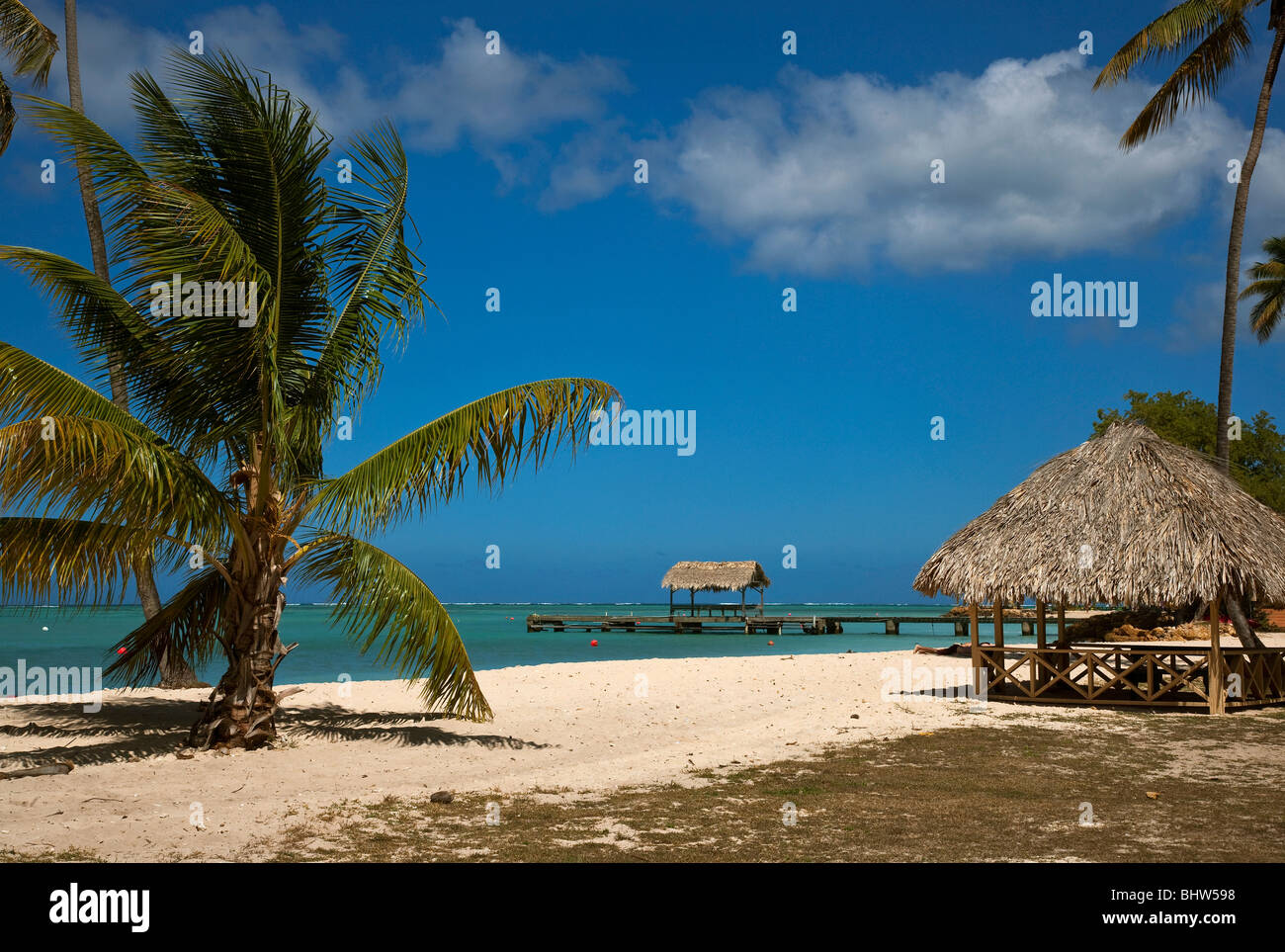 Das Strohdach Steg am Pigeon Point Heritage Park Tobago gegen einen blauen Himmel und türkisblauem Meer. Stockfoto