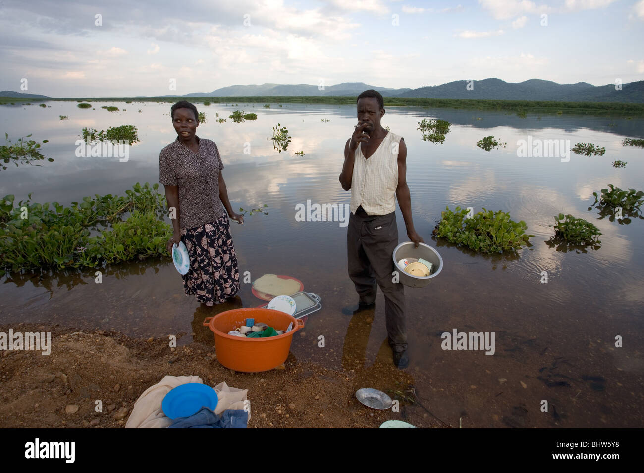 Mann und Frau waschen, Geschirr und Besteck in der West-Nil-Region von Uganda, Afrika Stockfoto